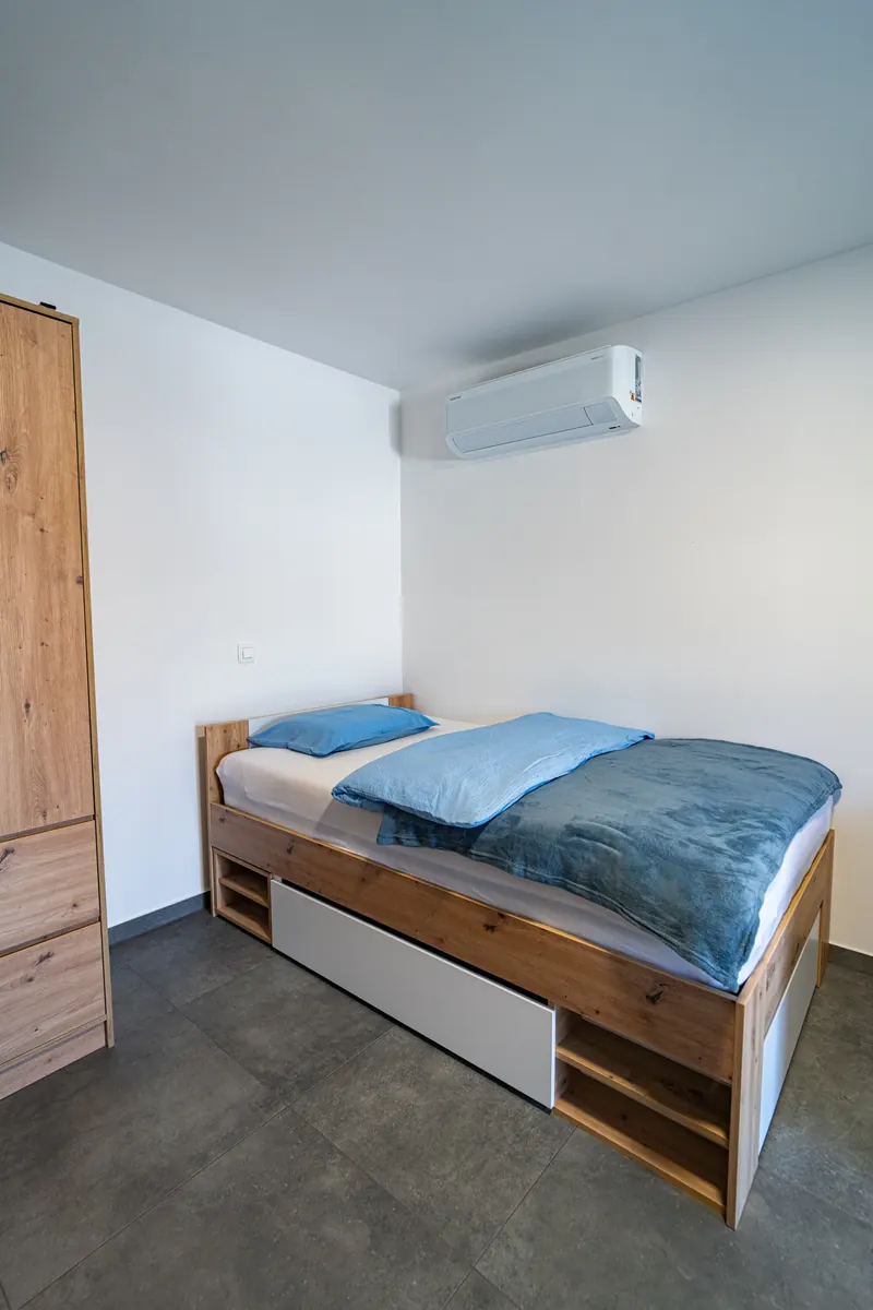 Spalnica z zakonsko posteljo, omaro in klimatsko napravo