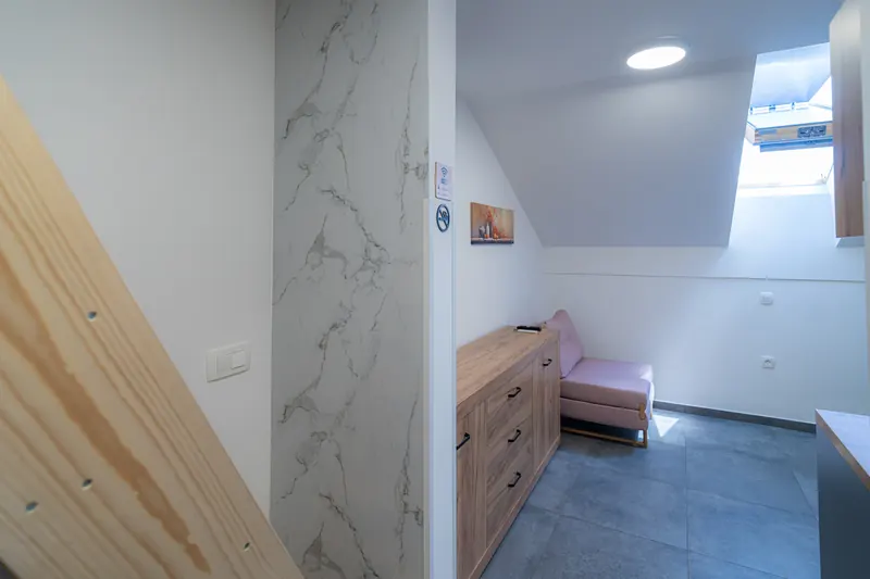 Kotiček z raztegljivim sedežem, leseno komodo in strešnim oknom